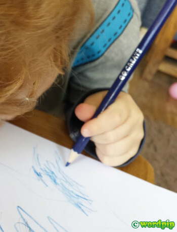 parent helping child to hold pencil correctly