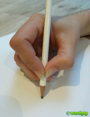adult hand holding pencil in a tripod grip