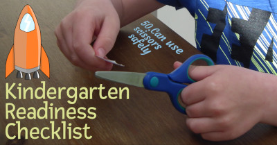 photo of a child using scissors at a table