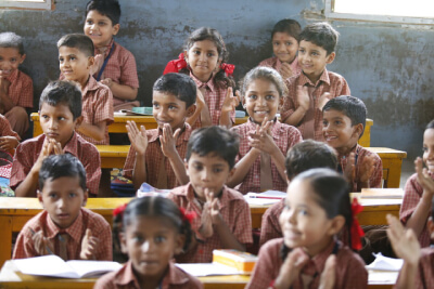 photo showing happy children at their desks in a classroom