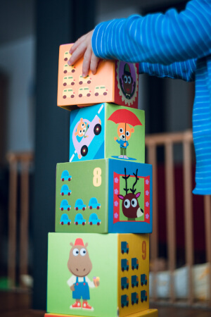child placing toy blocks on top of each other