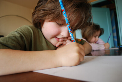 a child writing at a desk